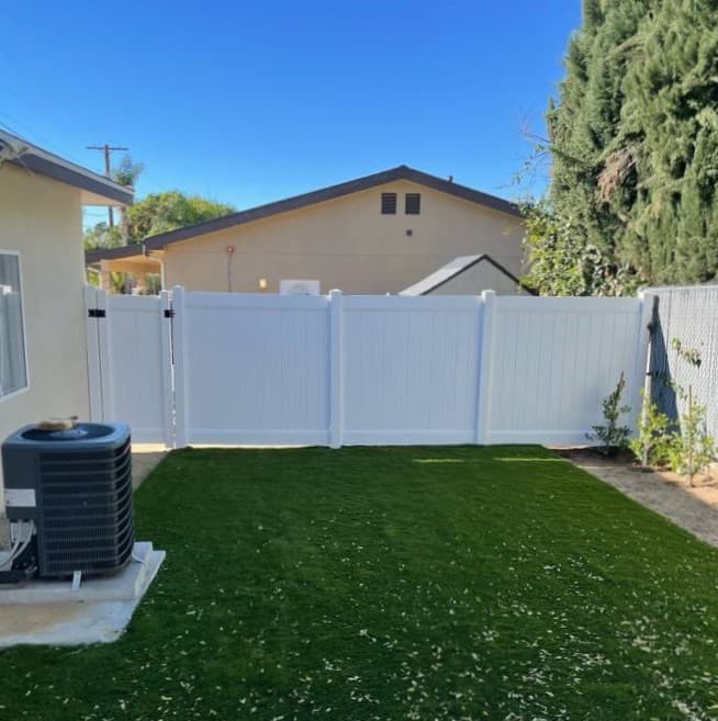 Picture of white vinyl fence surrounding a backyard
